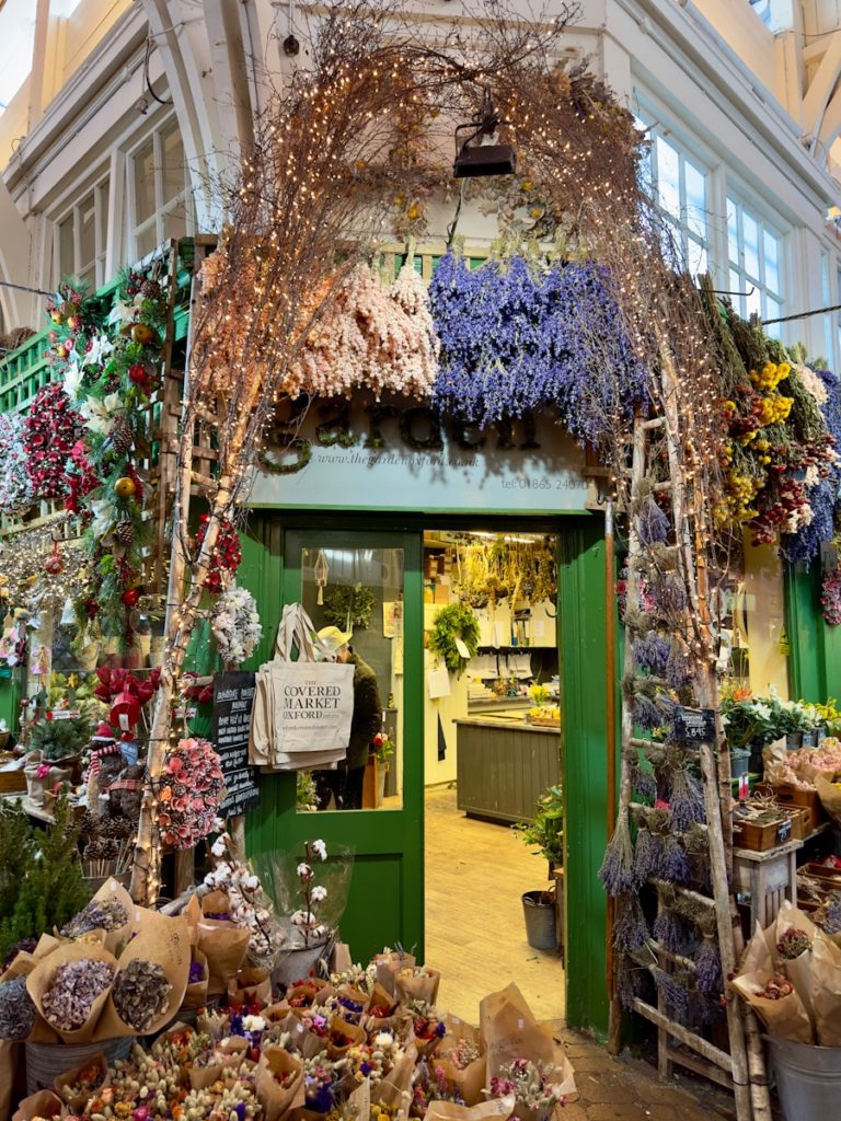 a store with a bunch of flowers hanging from the ceiling